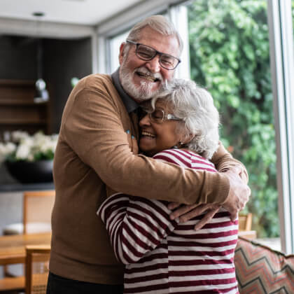 A mature couple hugging in a modern living room